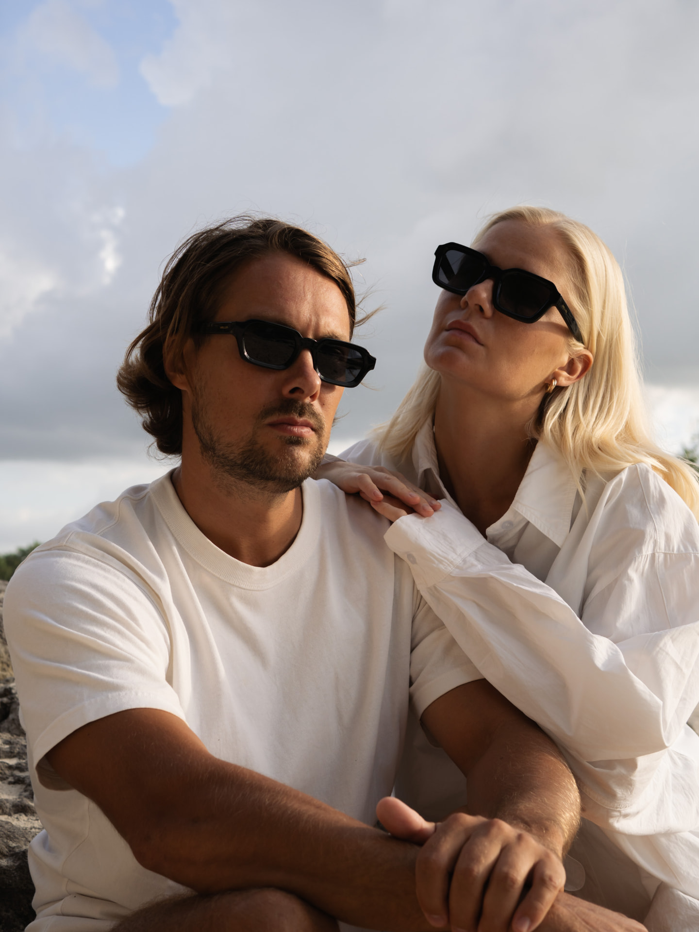 Two creators in sunglasses photographed outdoors at golden hour